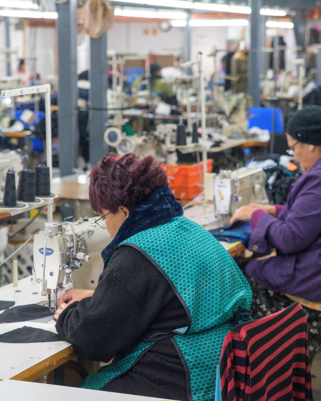 Industrial clothing manufacturing in South Africa with workers sewing garments in a CMT factory at BREETH Our CMT factory in South Africa where skilled workers craft high-quality garments with precision and care.